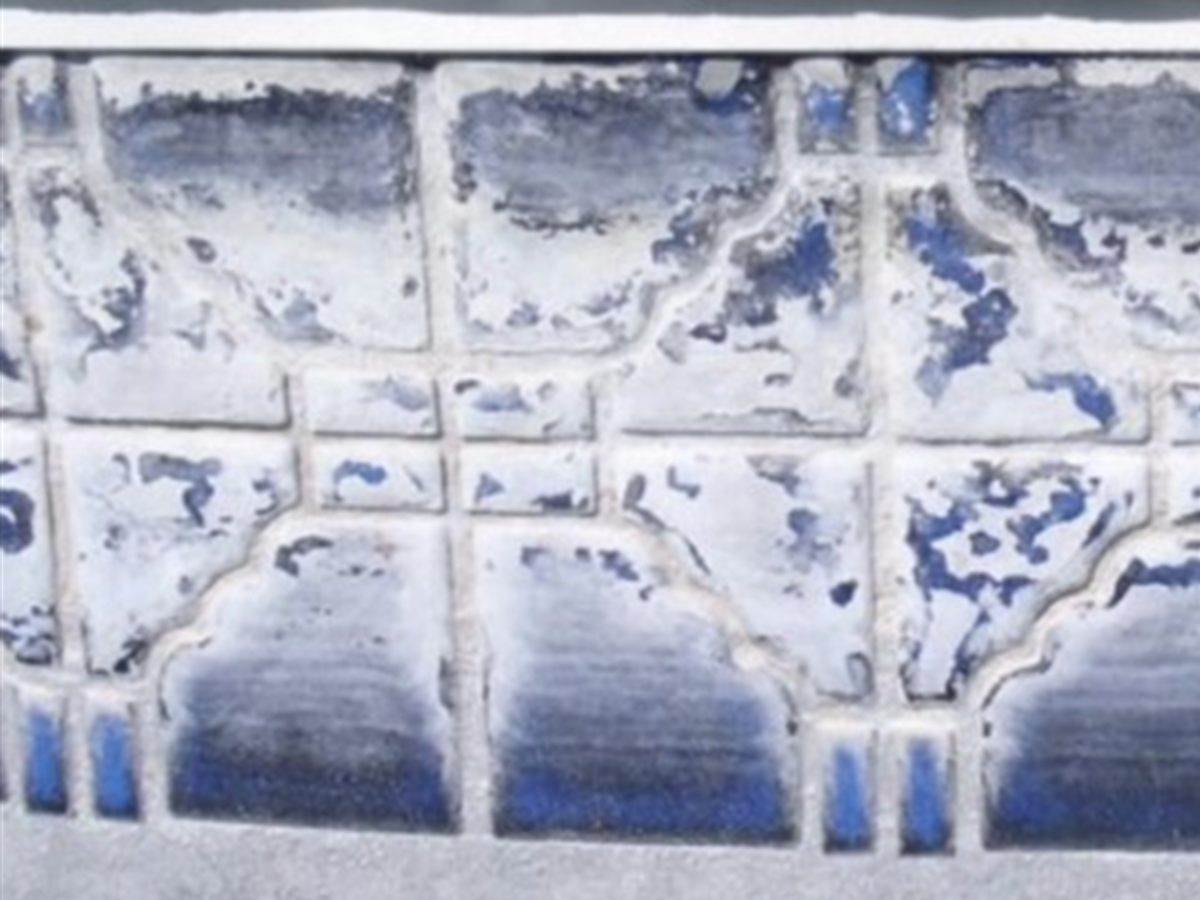 Blue pool tile buried under a thick white layer of hard water calcium