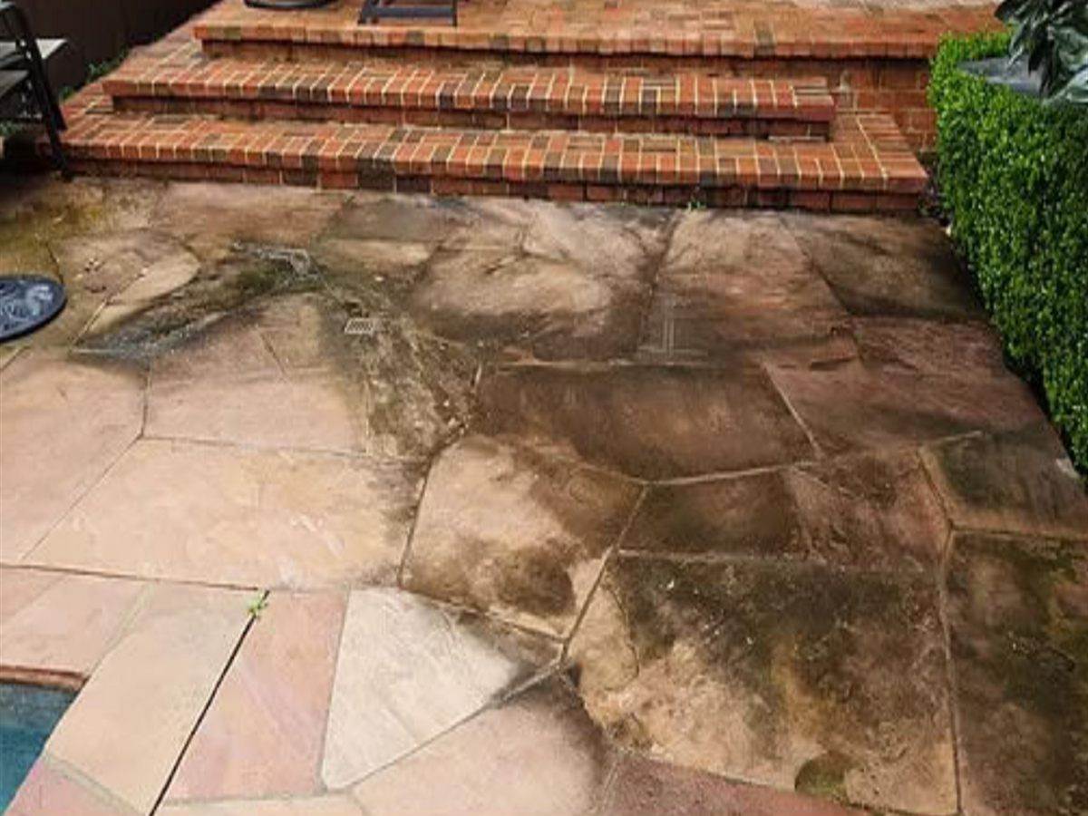 Flagstone pool deck darkened with algae, dirt and years of staining