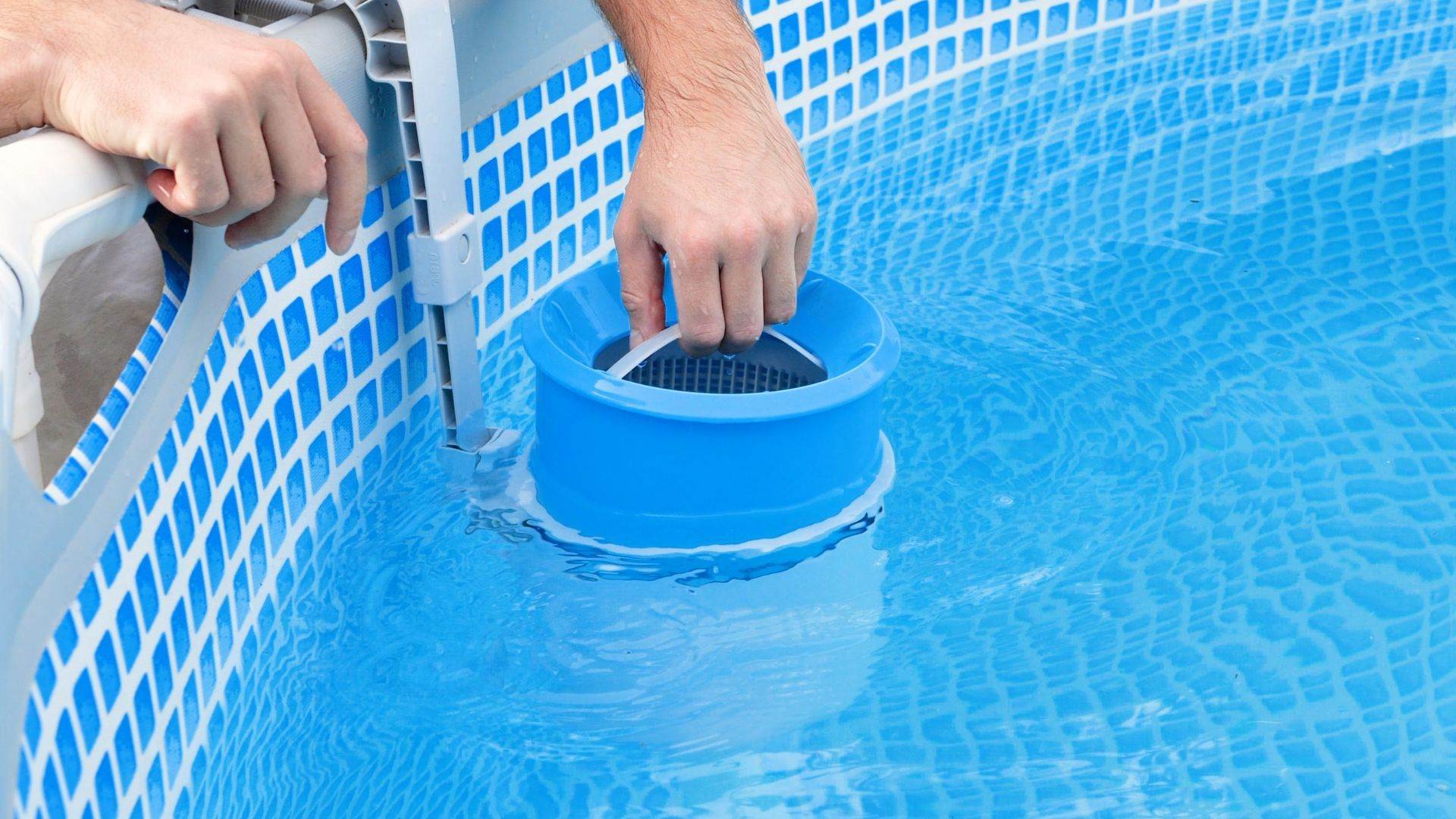 Hands lifting a skimmer basket during a pool service visit