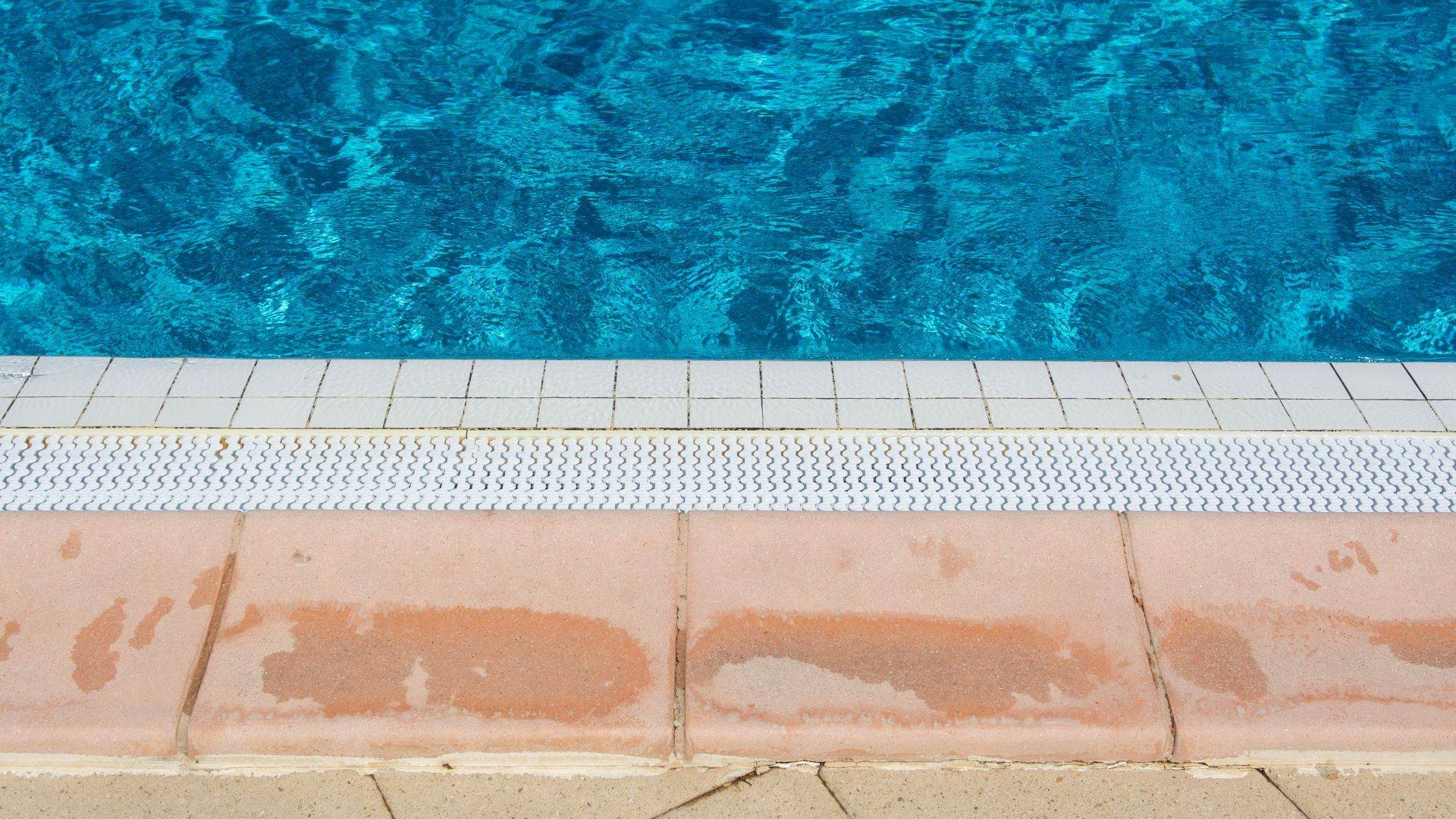 Pool coping and waterline showing storm staining