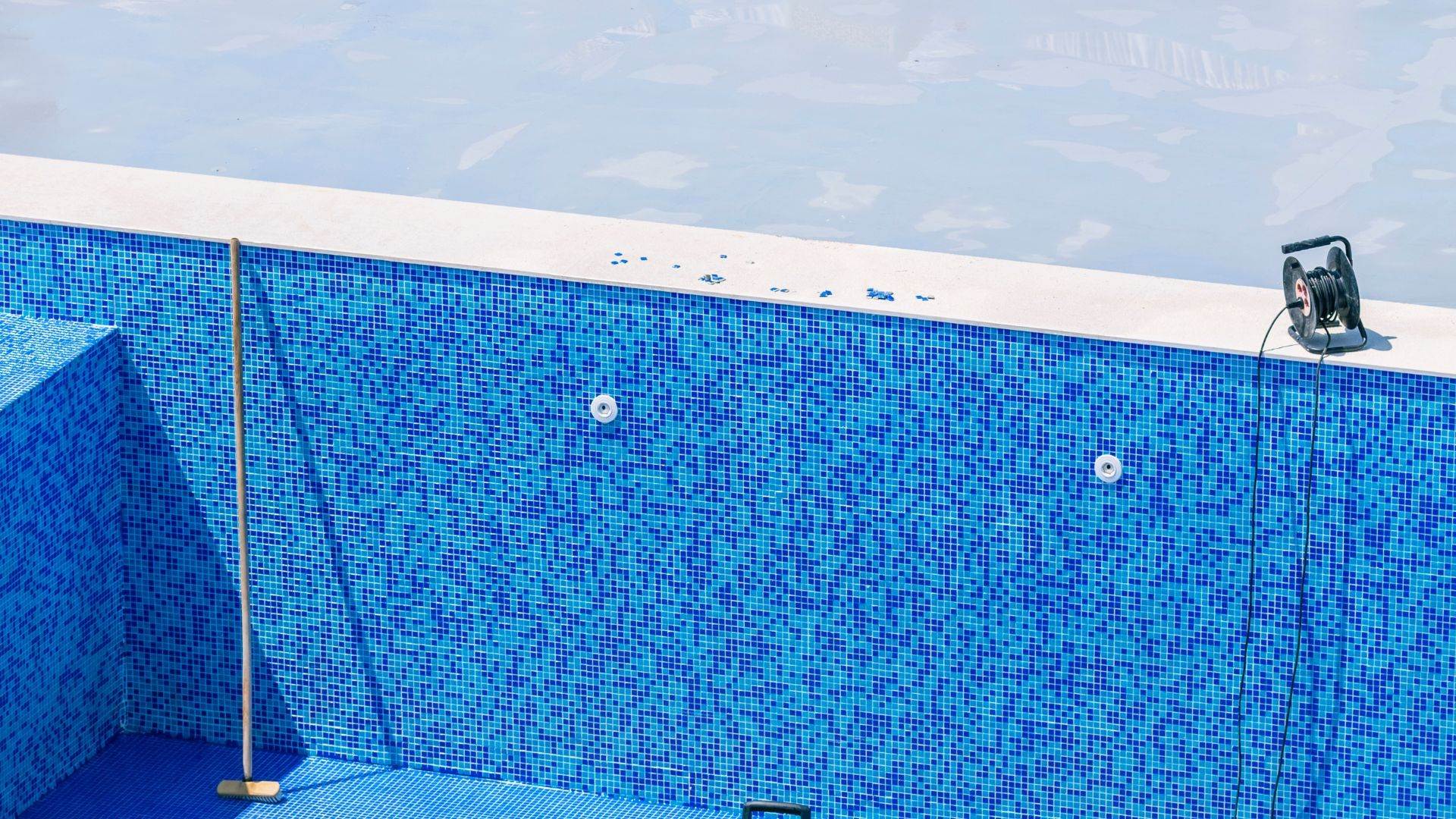Empty pool with mosaic tile walls during a drain and fill