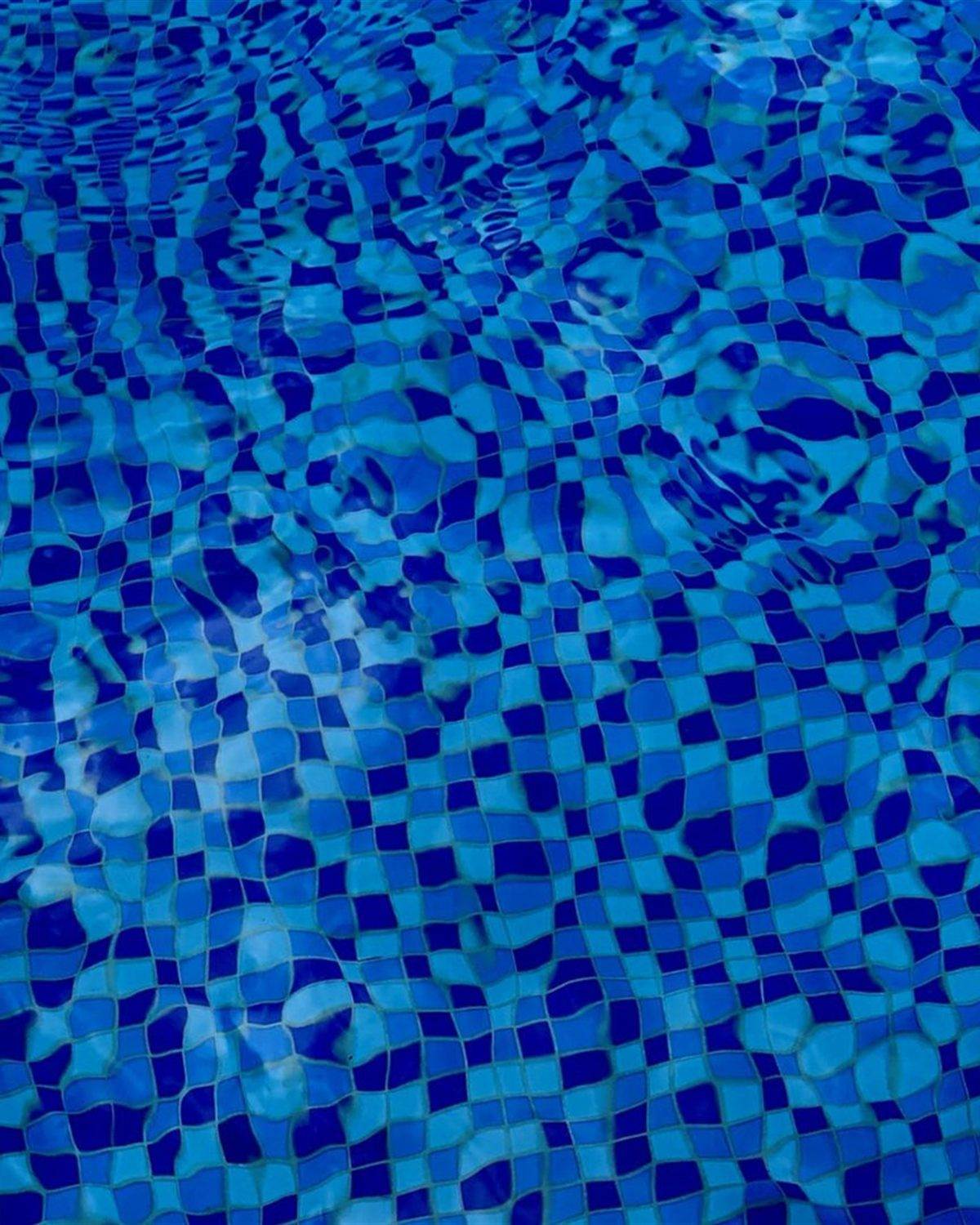 Deep royal blue pool floor seen through rippling water after coating
