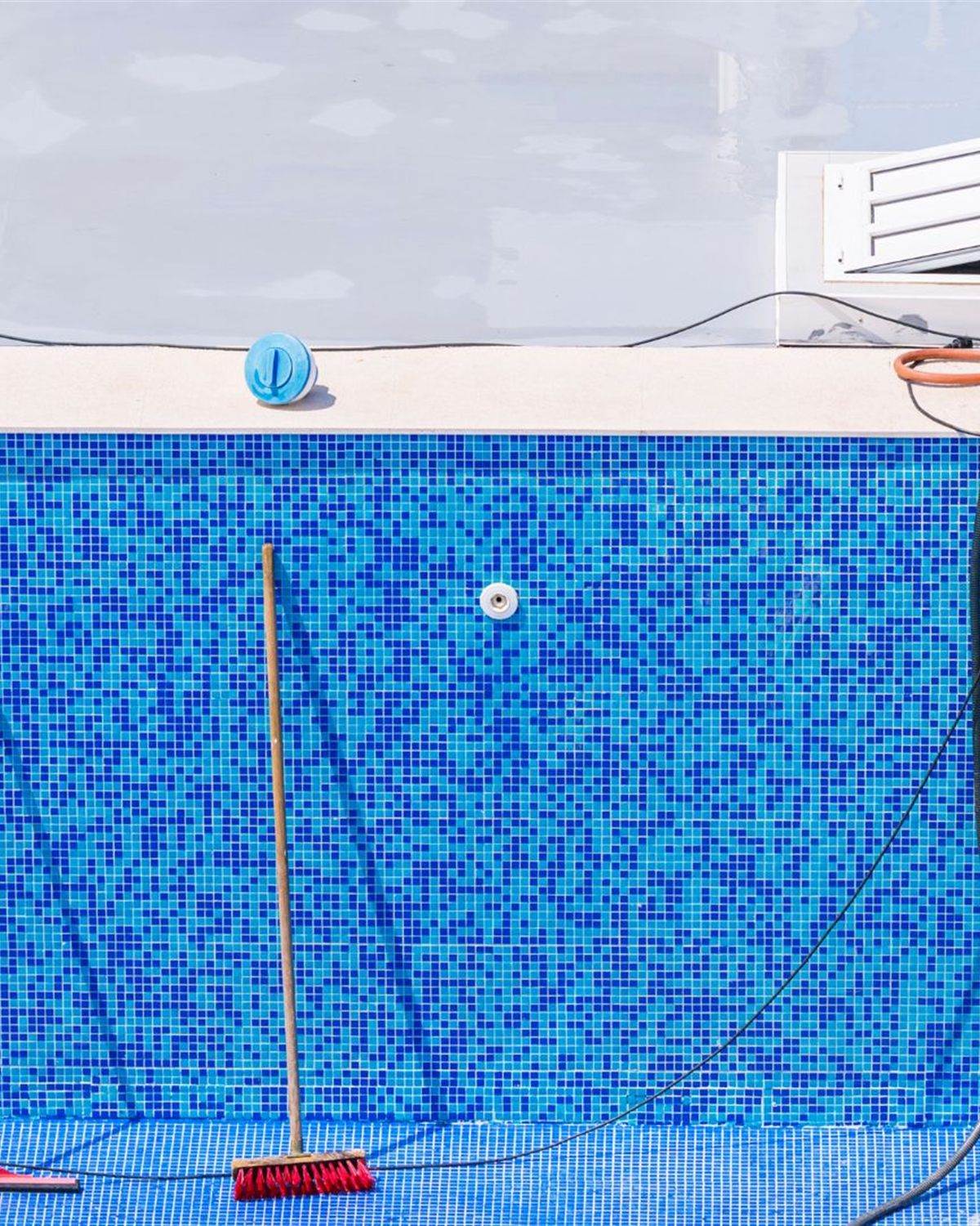 Empty pool with tools laid out during a drain and fill