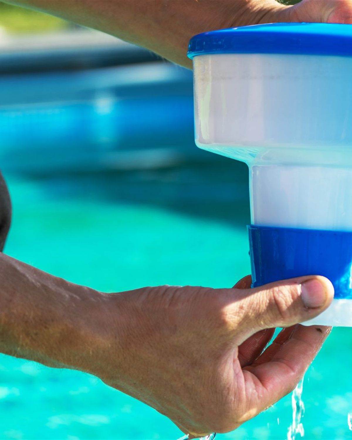 Floating chemical dispenser beside a turquoise pool