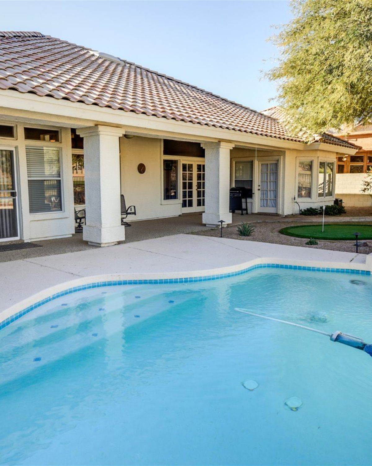 Tolleson, AZ backyard pool with block walls, palms and a covered patio