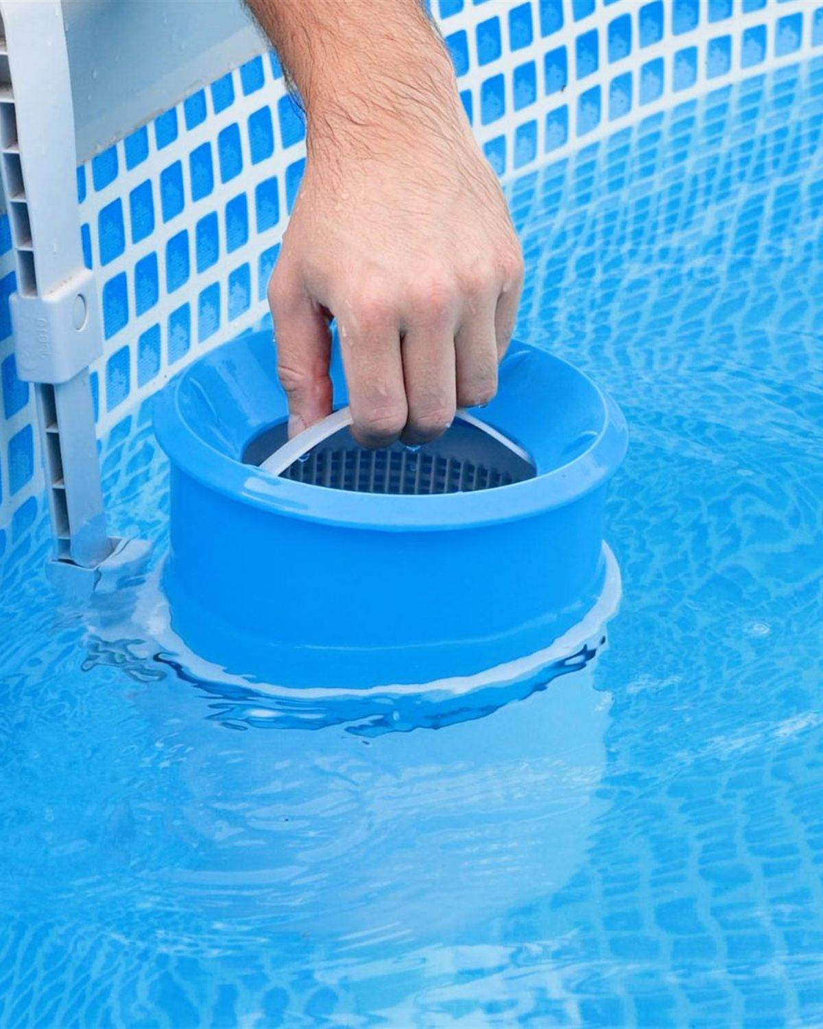 Hands lifting a skimmer basket out of a pool during a weekly pool service call