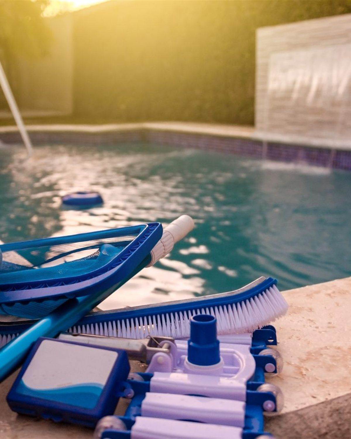 Pool cleaning equipment and hose beside a pump on an equipment pad